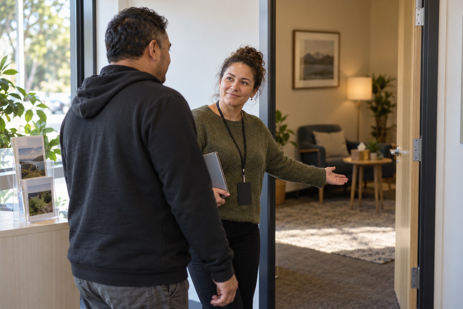 Support worker welcoming a visitor to a counselling room